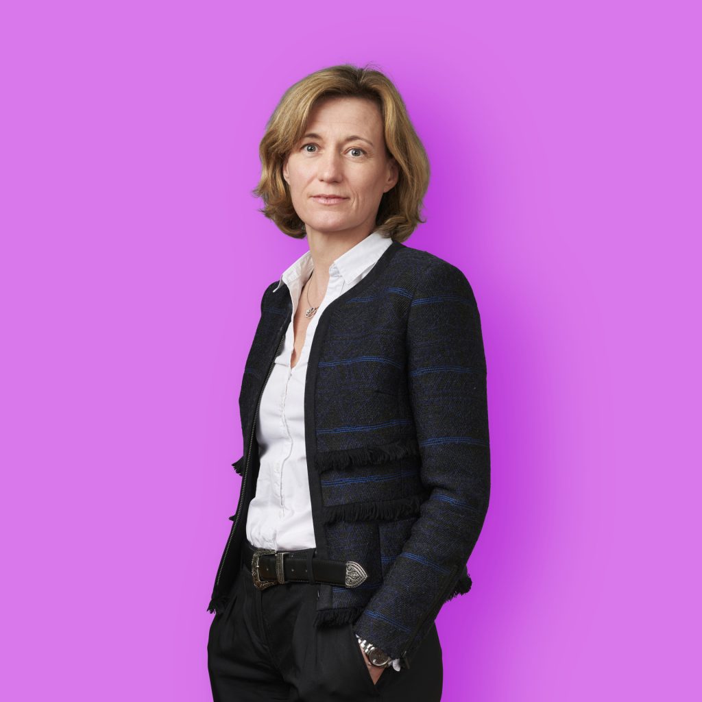 photographe Photographe aux cheveux blonds courts en portrait de mode, studio de Paris, blazer sombre et chemise blanche, fond violet. Paris