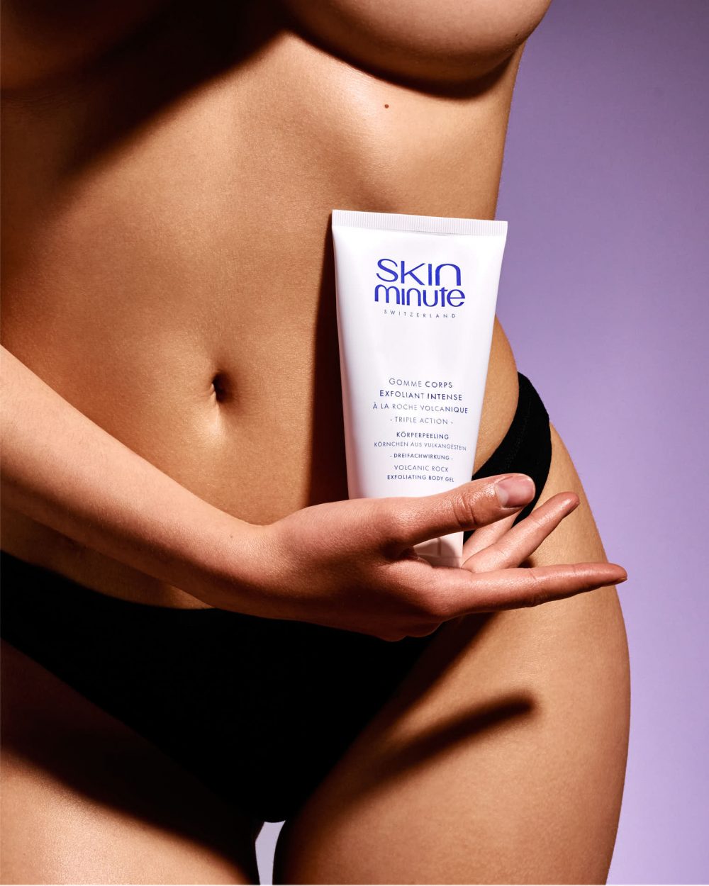 photographe Photographe mode beauté à Paris : portrait d'une personne en sous-vêtements noirs tenant un gommage Skin Minute, fond violet vif. Paris