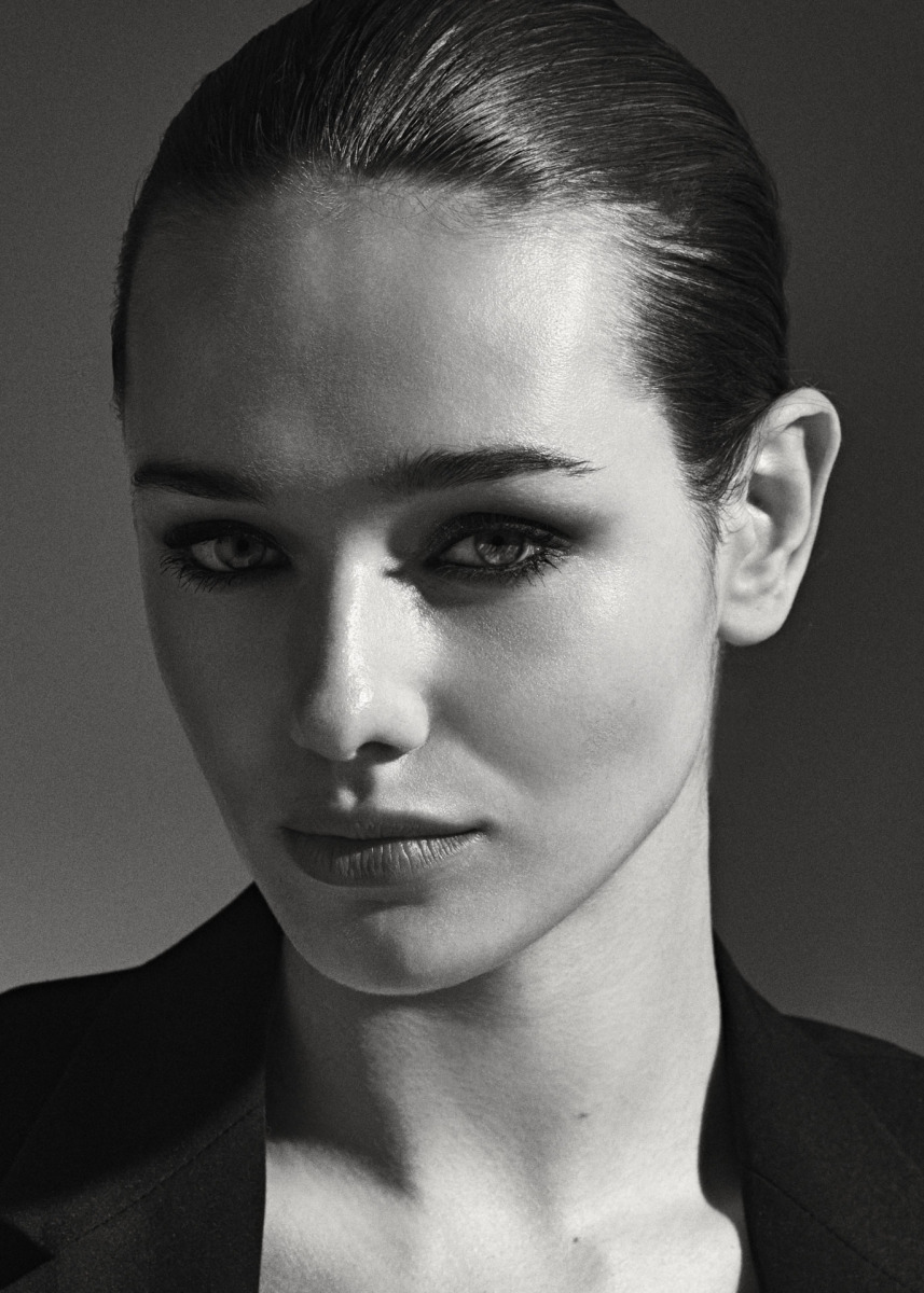 photographe Portrait mode noir et blanc à Paris par photographe : femme cheveux plaqués, blazer sombre, expression sérieuse, fond uni. Paris