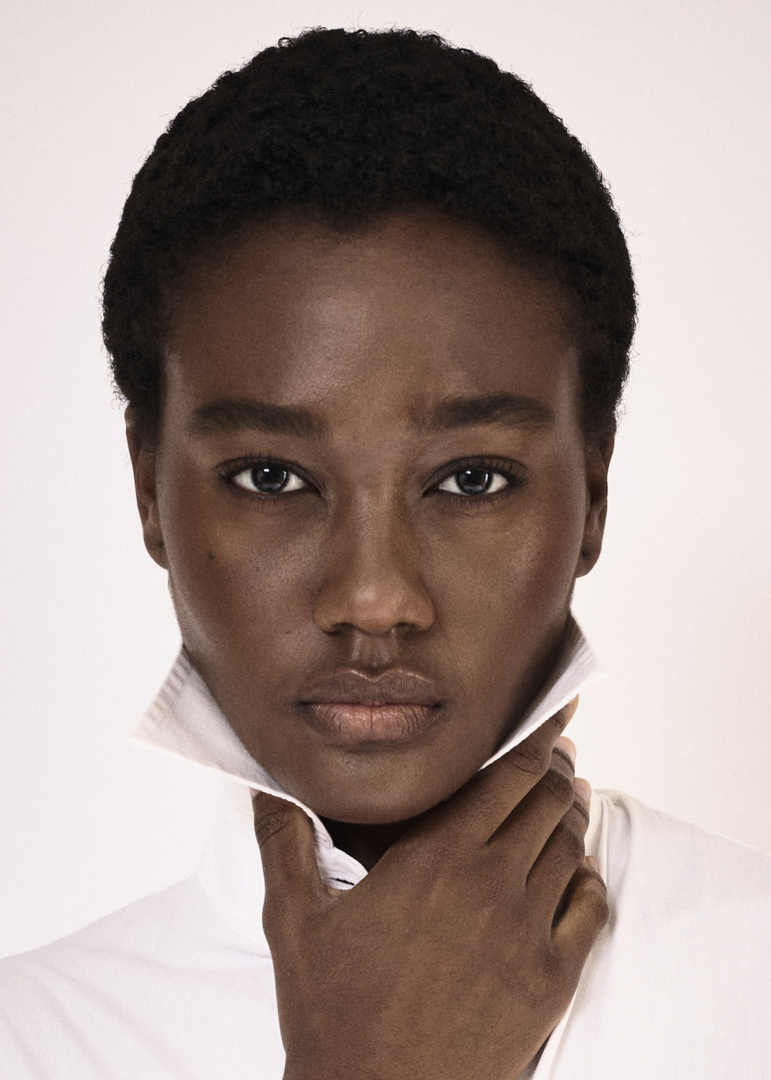 photographe Portrait mode à Paris : photographe capture une personne aux cheveux courts et bouclés, expression sérieuse, top blanc élégant. Paris